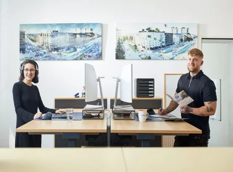 stadtmobil Büro, Kundenbetreuerin ist am Telefon und Kundenbetreuer hält Starterpaket 