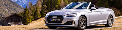 Silbernes Audi A5 Cabrio dahinter eine Berglandschaft