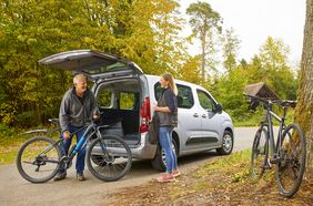 Paar lädt im Wald Fahrräder aus dem stadtmobil-Fahrzeug